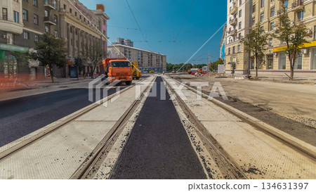 Workers operating asphalt paver machines during road construction and repairing works timelapse Workers operating asphalt paver machines during road construction and repairing works timelapse 134631397