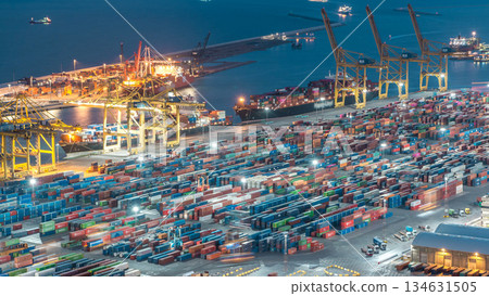 Seaport and loading docks at the port with cranes and multi-colored cargo containers day to night timelapse Seaport and loading docks at the port with cranes and multi-colored cargo containers day to night timelapse 134631505