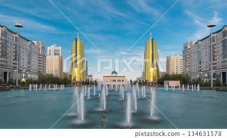 A square in front of Ak Orda with yellow towers timelapse hyperlapse and fountain in the foreground. A square in front of Ak Orda with yellow towers timelapse hyperlapse and fountain in the foreground. 134631578