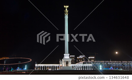 Stele monument Kazakh Eli with bird Samruk and Palace of Independence timelapse hyperlapse at night. 134631648