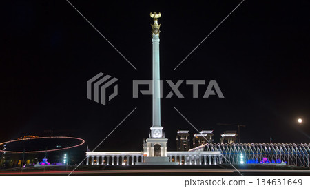Stele monument Kazakh Eli with bird Samruk and Palace of Independence timelapse hyperlapse at night. 134631649