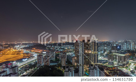 City skyline with commercial port of Singapore aerial night timelapse. 134631780