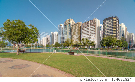 Corniche boulevard beach park along the coastline in Abu Dhabi timelapse hyperlapse with skyscrapers on background. 134631824