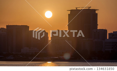 Abu Dhabi city skyline on sunrise time with water reflection timelapse. Abu Dhabi city skyline on sunrise time with water reflection timelapse. 134631850