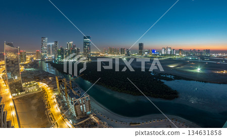 Buildings on Al Reem island in Abu Dhabi day to night timelapse from above. 134631858