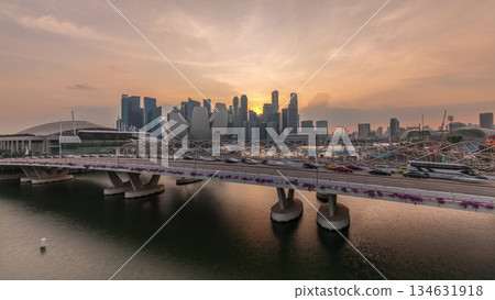 Aerial view of sunset over Helix Bridge and Bayfront Avenue with traffic timelapse at Marina Bay, Singapore 134631918