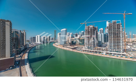Skyscrapers near canal in Dubai with blue sky aerial timelapse Skyscrapers near canal in Dubai with blue sky aerial timelapse 134631970