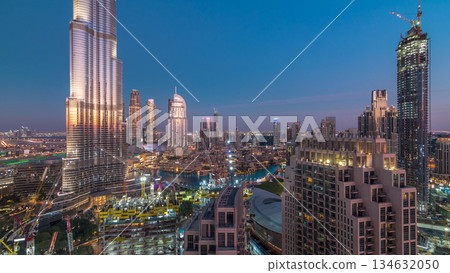 Panoramic skyline view of Dubai downtown after sunset with mall, fountains and skyscrapers aerial day to night timelapse Panoramic skyline view of Dubai downtown after sunset with mall, fountains and skyscrapers aerial day to night timelapse 134632050