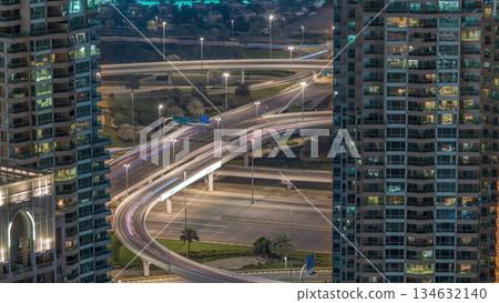 Dubai Marina highway exit between skyscrapers, spaghetti junction aerial night timelapse 134632140
