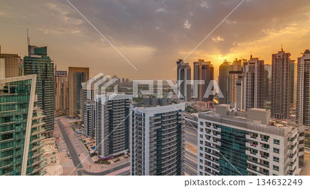 Sunrise view of various skyscrapers and towers in Dubai Marina from above aerial timelapse 134632249