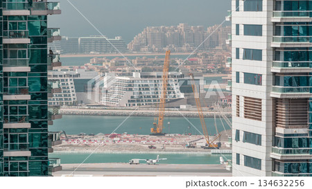Aerial view to Dubai marina skyscrapers with construction site and Palm Jumeirah Island on background timelapse. Aerial view to Dubai marina skyscrapers with construction site and Palm Jumeirah Island on background timelapse. 134632256