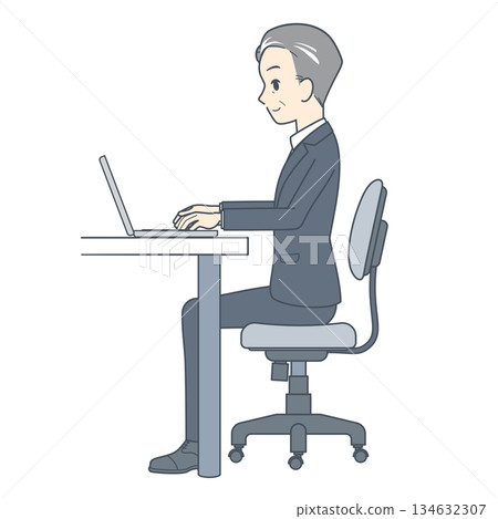 一位中年商務人士側身坐在辦公桌前，使用筆記型電腦工作。 134632307