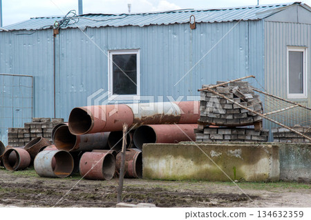 Construction materials storage with metal pipes and paving bricks Construction materials storage with metal pipes and paving bricks 134632359