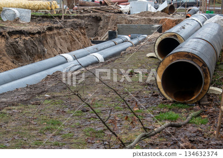 District heating pipeline installation in open trench on construction site 134632374