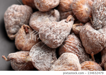 Dried figs covered with powdered sugar on a ceramic surface 134632479