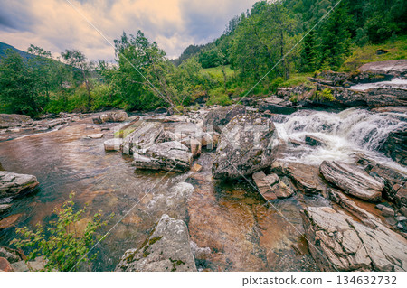 Beautiful mountain river. Cascade mountain stream with rapids and a waterfall 134632732