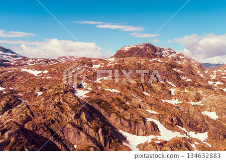 Peaks of the mountains, covered with melting snow. Nature park in Sauda municipality. Beautiful nature of Norway, Europe Peaks of the mountains, covered with melting snow. Nature park in Sauda municipality. Beautiful nature of Norway, Europe 134632883