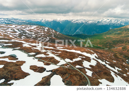 Aerial view of snow-covered mountain in summer. High mountain road Bjorgavegen. Aurlandsvegen, Aurland, Norway Aerial view of snow-covered mountain in summer. High mountain road Bjorgavegen. Aurlandsvegen, Aurland, Norway 134632886