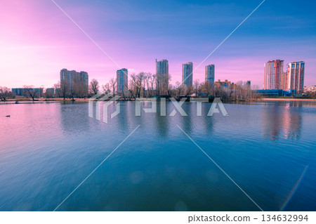 Kyiv in the morning. Left bank of the Dnieper River. Beautiful reflection of buildings in the lake 134632994