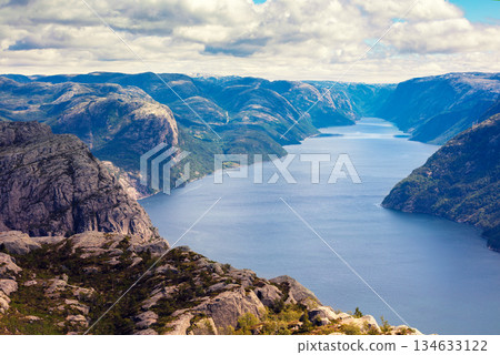 View of the beautiful Lysefjord on a cloudy day. The rocky shore of the majestic Lysefjord. Beautiful wildlife of Norway. View from Preikestolen View of the beautiful Lysefjord on a cloudy day. The rocky shore of the majestic Lysefjord. Beautiful wildlife of Norway. View from Preikestolen 134633122