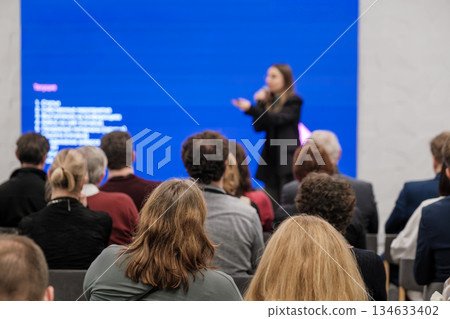 Speaker presenting to an audience in a conference with a blue screen background Speaker presenting to an audience in a conference with a blue screen background 134633402