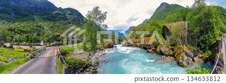 Panoramic view of a beautiful mountain river. Cascade mountain stream with rapids. Briksdal glacier hike Briksdalsbreen mountain lodge 134633812