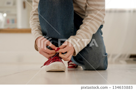 Young Girl Tying Laces On Sneakers 134633883