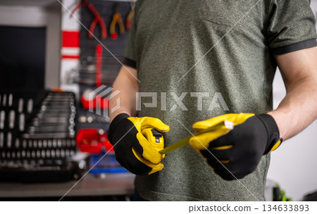 Worker Holding Measuring Tape In Hands 134633893