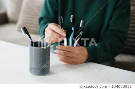 Girl Placing Toothbrushes In Holder For Brushes Girl Placing Toothbrushes In Holder For Brushes 134633931