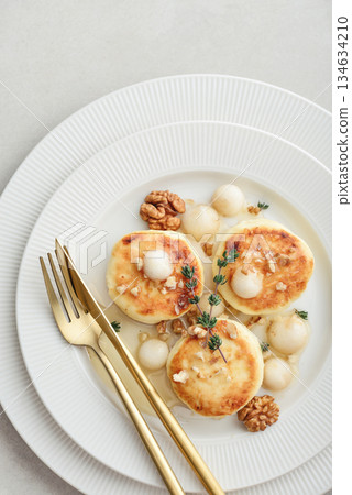 cottage cheese pancakes, syrniki, curd fritters served with pear balls, walnut and honey cottage cheese pancakes, syrniki, curd fritters served with pear balls, walnut and honey 134634210