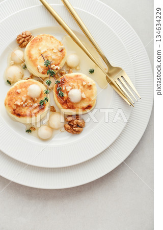 cottage cheese pancakes, syrniki, curd fritters served with pear balls, walnut and honey cottage cheese pancakes, syrniki, curd fritters served with pear balls, walnut and honey 134634229