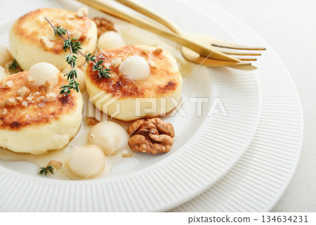 cottage cheese pancakes, syrniki, curd fritters served with pear balls, walnut and honey cottage cheese pancakes, syrniki, curd fritters served with pear balls, walnut and honey 134634231