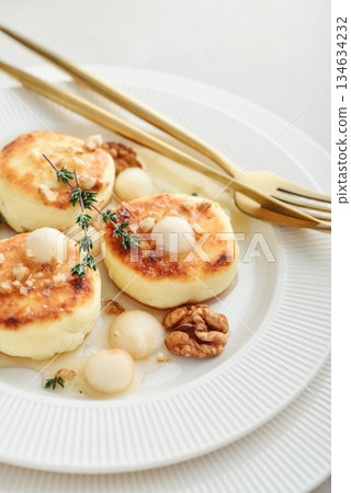 cottage cheese pancakes, syrniki, curd fritters served with pear balls, walnut and honey cottage cheese pancakes, syrniki, curd fritters served with pear balls, walnut and honey 134634232