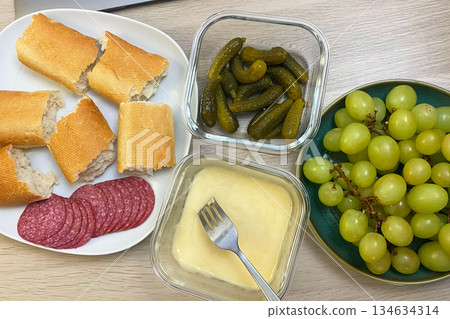 Appetizer Platter with Melted Cheese, Salami, Bread, Pickles, and Grapes Appetizer Platter with Melted Cheese, Salami, Bread, Pickles, and Grapes 134634314