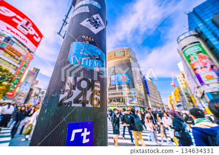 日本東京的城市景觀又貼滿了貼紙……又到年底了。澀谷依然迎來絡繹不絕的入境遊客，其中大部分是外國遊客。照片裡那根柱子上的貼紙已經被撕掉了。 134634331
