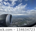 The view of the scenery and sky below from the window of an airplane 134634723