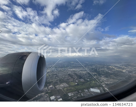 The view of the scenery and sky below from the window of an airplane The view of the scenery and sky below from the window of an airplane 134634723