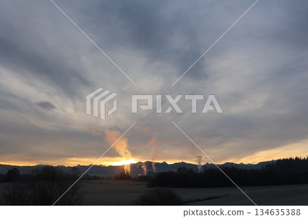 Industrial Smoke at Sunrise Over Mountain Landscape Industrial Smoke at Sunrise Over Mountain Landscape 134635388