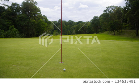Golf ball is on a green lawn in a beautiful golf course with morning sunshine. 134635491
