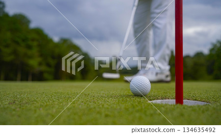 Golf ball is on a green lawn in a beautiful golf course with morning sunshine. 134635492