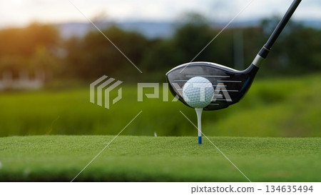 Golf clubs and golf balls on a green lawn in a beautiful golf course with morning sunshine. Golf clubs and golf balls on a green lawn in a beautiful golf course with morning sunshine. 134635494