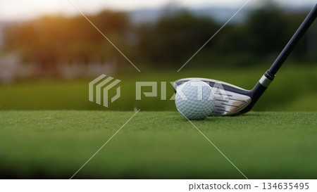 Golf clubs and golf balls on a green lawn in a beautiful golf course with morning sunshine. Golf clubs and golf balls on a green lawn in a beautiful golf course with morning sunshine. 134635495