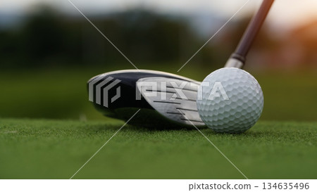 Golf clubs and golf balls on a green lawn in a beautiful golf course with morning sunshine. 134635496
