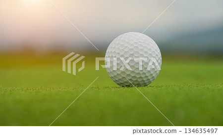 Golf ball on green grass in the evening golf course with sunshine background. 134635497