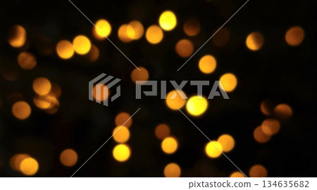 Warm yellow, orange, and red bokeh lights shimmering in motion against a black night backdrop, evoking a romantic light tone. Warm yellow, orange, and red bokeh lights shimmering in motion against a black night backdrop, evoking a romantic light tone. 134635682