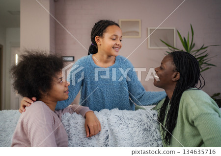 African american mother and daughters laughing together at home African american mother and daughters laughing together at home 134635716