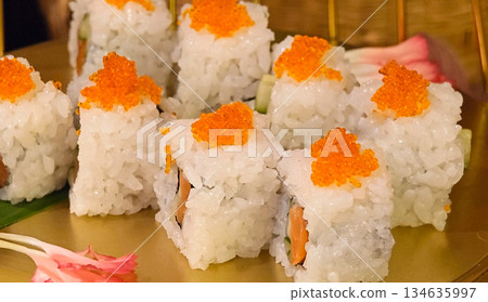 Delicious, fresh sushi with bright orange tones presented on a traditional Japanese plate. Delicious, fresh sushi with bright orange tones presented on a traditional Japanese plate. 134635997