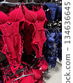 Bright red and navy lingerie sets hang neatly on racks in a retail clothing store display 134636645