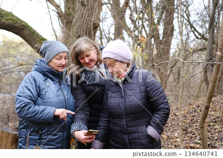 three adult retired women elderly women enjoying a peaceful moment by the lake, embracing each other and sharing a heartwarming connection at sunset three adult retired women elderly women enjoying a peaceful moment by the lake, embracing each other and sharing a heartwarming connection at sunset 134640741