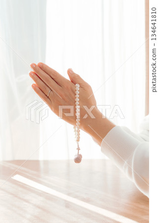 一位中年婦女在家中為逝者祈禱。 一位中年婦女在家中為逝者祈禱。 134641810